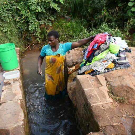 Woman washing clothes in a community environment